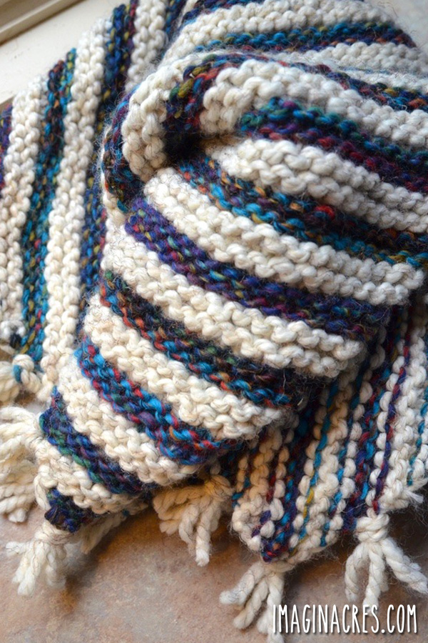 A blue and white striped baby blanket folded.