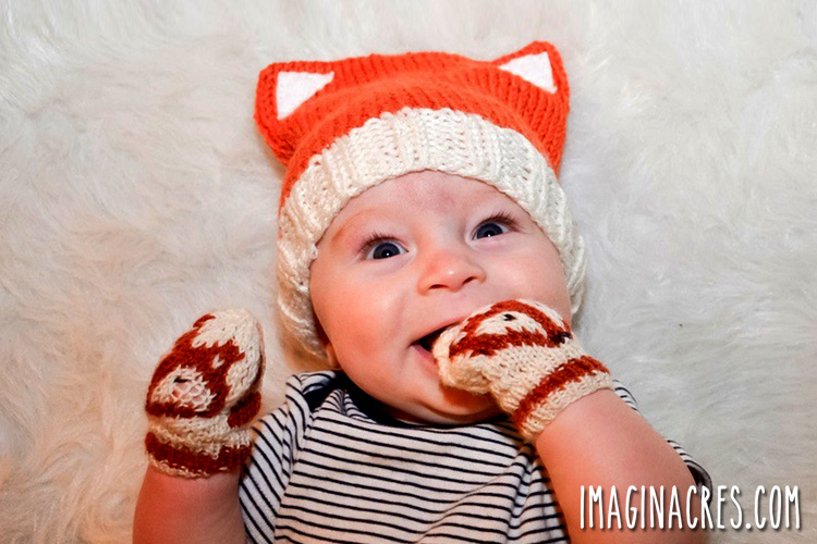 cute baby wearing the knitted fox hat and mittens