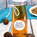 A bottle of homemade black walnut extract on a table.