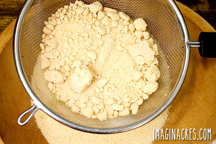 sifting maple sugar through a wire strainer